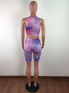 Back view of a tie-dye two-piece set featuring a crop top and cycling shorts on a mannequin