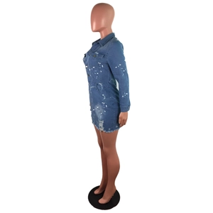 Detail view of denim mini dress featuring white paint splatters and distressed frayed hem