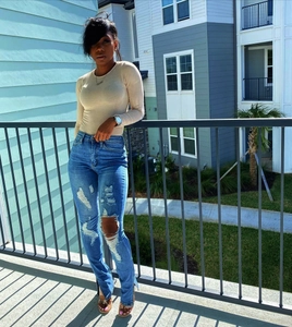 Dames top met lange mouwen en high waist skinny jeans met scheuren en zijsplit
