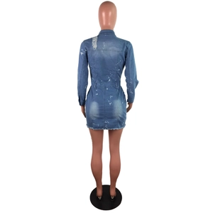 Detail of blue denim dress back with white paint splatter and distressed ripped shoulder hole