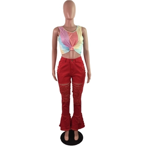 Detail shot of distressed red flare jeans with ripped knee design and frayed edges