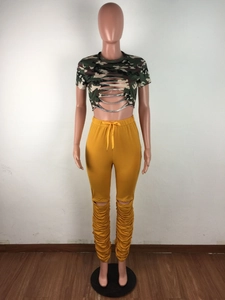 Détail du pantalon jaune empilé à taille haute avec genou déchiré et cordon serrage