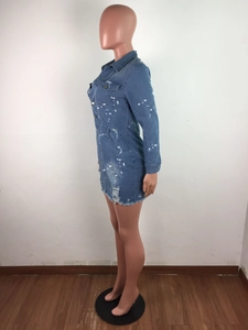 Detail of slim fit denim mini dress with distressed frayed hem and paint splatters