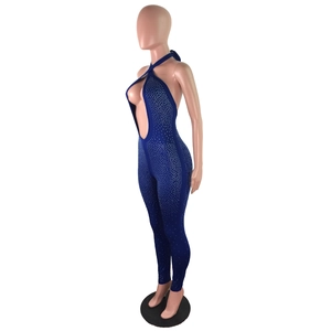 Dettaglio della tuta blu navy con scollo a cavezza, strass scintillanti e profondo scollo a V