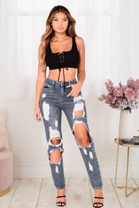 Dettaglio dei jeans skinny a vita alta azzurri con strappi e tagli sulle ginocchia