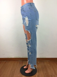 Détails de ce jean bleu clair avec déchirures, franges et fente latérale irrégulière