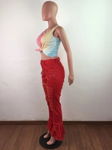 Detailed view of red flare jeans featuring distressed ripped texture and ruffled leg hems