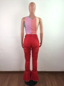 Detail view of red flare jeans featuring distressed holes and ruffled fringe hem on the back