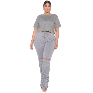 Détail du t-shirt court gris et pantalon empilé avec découpes aux genoux et cordon