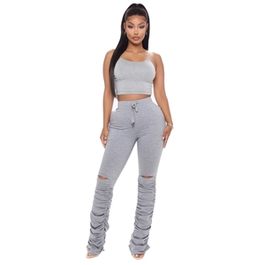 Détail du pantalon froncé gris avec découpes aux genoux et taille à cordon de serrage