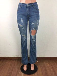 Gedetailleerde weergave van de blauwe distressed denim jeans met gaten en franjes