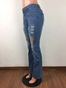 Detail van een blauwe gescheurde jeans met hoge taille en modieuze zijsplit-stijl