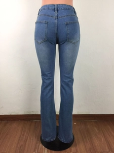Detailopname van de achterkant van een high-waist jeans met distressed franjes aan de zoom