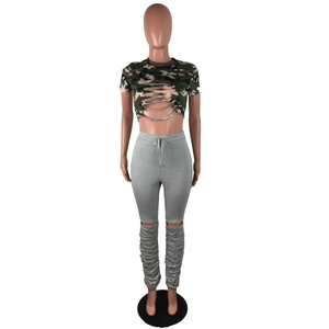 Détail du pantalon gris taille haute avec fentes aux genoux et ourlet froncé au bas