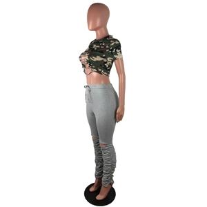 Détail du pantalon empilé gris et du crop top camouflage avec découpe sur mannequin