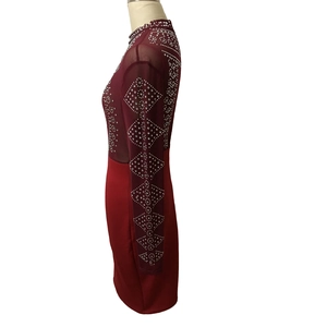 Detail of the sheer mesh sleeve with sparkling diamond patterns on a burgundy dress
