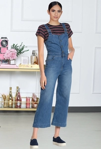 Detail eines dunkelblauen Denim-Jumpsuits mit Metallknöpfen und gestreiftem T-Shirt-Look