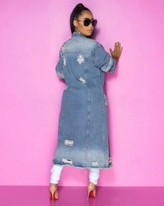 Dettaglio del trench in denim da donna con schiena strappata e orlo sfrangiato alla moda