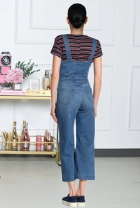 Rückansicht der Denim-Latzhose mit hoher Taille und Gesäßtaschen auf gestreiftem Shirt