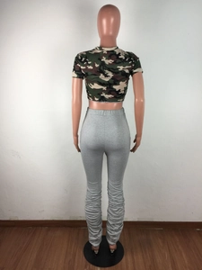 Détail du pantalon froncé gris avec haut court camouflage sur un mannequin de mode