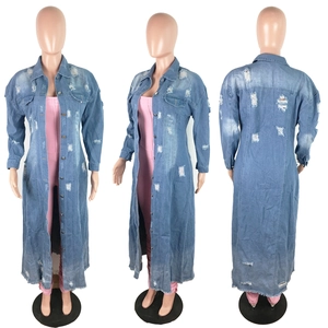 Dettaglio del trench in denim azzurro con strappi e decorazioni a frange distressed