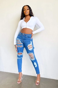 Détail d'un jean skinny taille haute avec genoux déchirés et design extensible ajusté