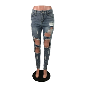 Dettaglio ravvicinato di jeans skinny azzurri con strappi e finiture in denim vissuto