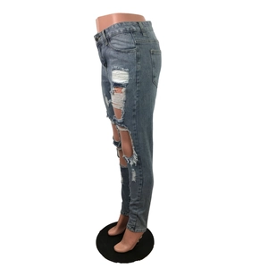 Dettaglio di jeans skinny azzurri con strappi pesanti e fori distressed sul lato