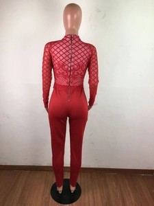Détail du dos d'une combinaison rouge en dentelle avec manches en mesh et fermeture dorée