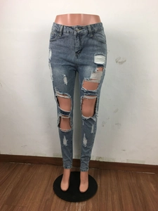 Dettaglio jeans azzurri a vita alta con strappi, bordi sfrangiati ed effetto invecchiato