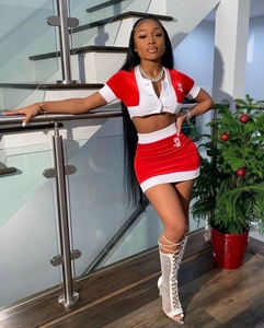 Detailed view of red velvet crop top and mini skirt set with white SJ embroidery