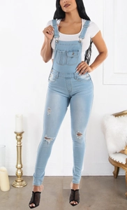Detail of ripped knee design and light blue denim texture on slim fit overalls