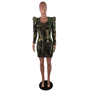 Détail de sequins verts et dorés avec motifs géométriques sur une robe de soirée à col V