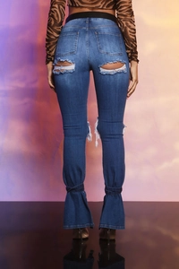 Vista posteriore di jeans svasati con dettagli strappati e lacci alle caviglie