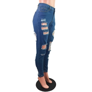 Vue détaillée du jean skinny bleu foncé avec déchirures et texture en denim extensible