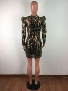 Détail du dos d'une robe à paillettes avec motifs géométriques or et vert et épaulettes