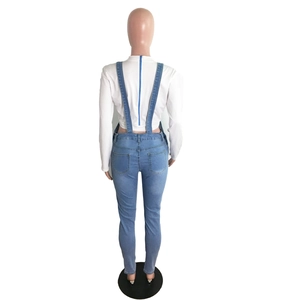 Detail view of denim overall back with high waist design and royal blue zipper on white top