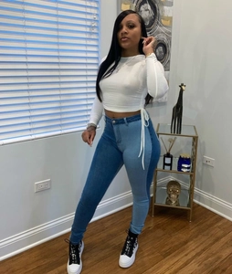 Gedetailleerd zicht op de tweekleurige skinny jeans met hoge taille en korte top