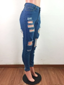 Détail d'un jean skinny taille haute avec de larges déchirures et des moustaches délavées