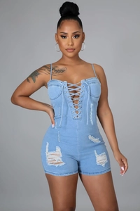 Gros plan du combishort en jean bleu clair avec laçage frontal et détails déchirés
