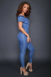 Side view of slim fit off-shoulder denim jumpsuit with lace-up detail and wash finish