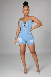 Détail d'un combishort en jean bleu clair avec laçage frontal et ourlet effiloché usé
