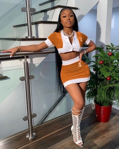 Detail of a two-piece orange and white knit set with polo top and mini skirt featuring SJ logo