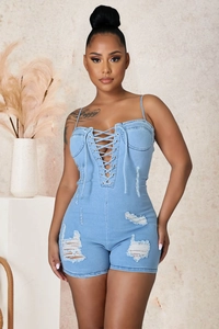 Détail du corsage à lacets et du tissu vieilli sur un combishort en jean bleu clair