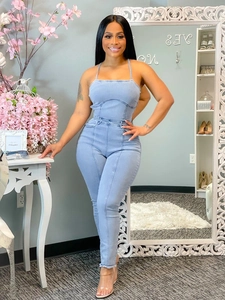 Détail de la combinaison en jean bleu clair avec ourlet effiloché et coutures contrastées