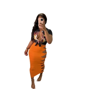 Detail of high-waist orange midi skirt featuring stylish side cutout and knot detail