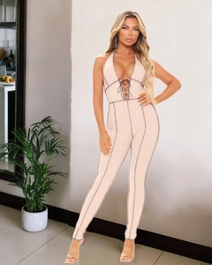 Detailed close-up of ribbed beige jumpsuit with halter neck and contrast stitching