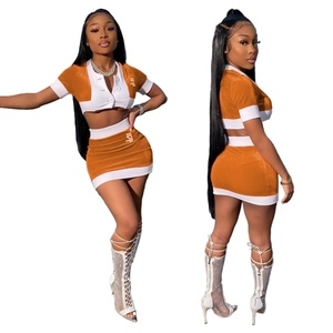 Two-piece orange velvet crop top and mini skirt set with white contrast trim and crown logo