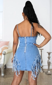 Détail de la fermeture éclair au dos et des franges sur cette robe en jean bleu ajustée