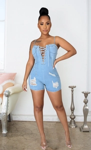 Détails d'un combishort en jean bleu clair avec laçage frontal et ourlet effiloché